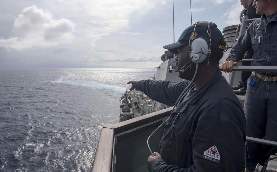 Seaman Dorsey Cadette, left, of the guided-missile destroyer USS Stethem, points out a smoke signal during man-overboard training in the South China Sea, July 10, 2017.