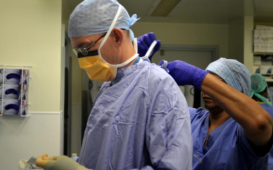 Maj. Richard Knight, urologist with the 48th Medical Group based at RAF Lakenheath, dons surgical gear before robotic-assisted surgery at the Norfolk and Norwich University Hospital in Norwich, England, Monday, July 31, 2017. Military doctors like Knight have been working at British hospitals under an agreement with the 48th MDG.