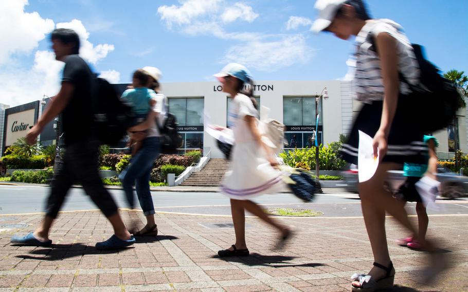 A Japanese family walks around Tamuning, Guam, while on vacation, Tuesday, Aug. 15, 2017.