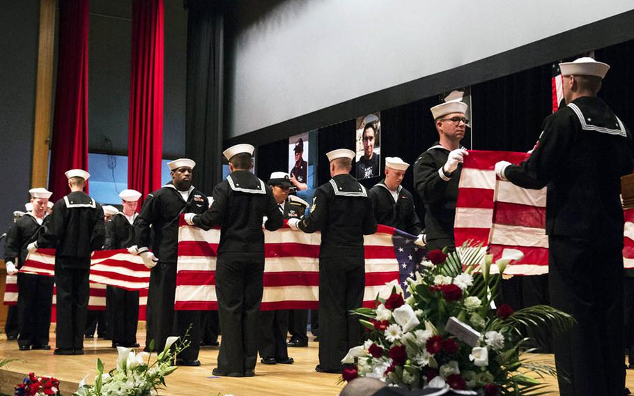 Sailors ceremonially fold seven American flags during a memorial ceremony on June 27, 2017, at Yokosuka Naval Base, Japan, for the USS Fitzgerald sailors who were killed in a collision at sea on June 17.