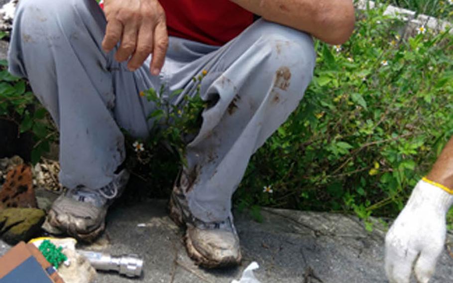 Heizaburo Yamauchi of the Okinawa Lime Cave Association displays human remains found at Amachijo Gama in Nanjo during his brief visit to the cave in late June.