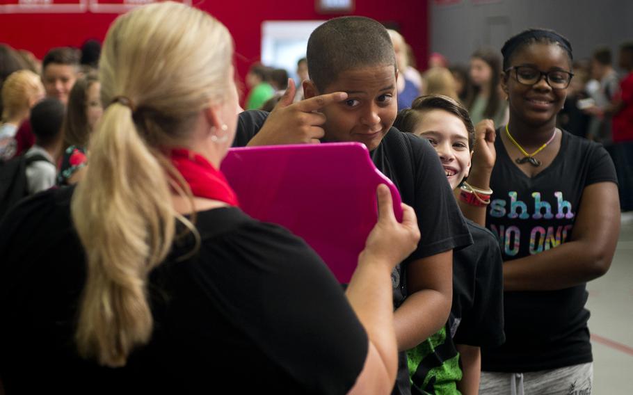 A Kaiserslautern Middle School student makes last-minute adjustments in the mirror before school photos during the first day of school at Vogelweh, Germany, on Monday, Aug. 28, 2017.