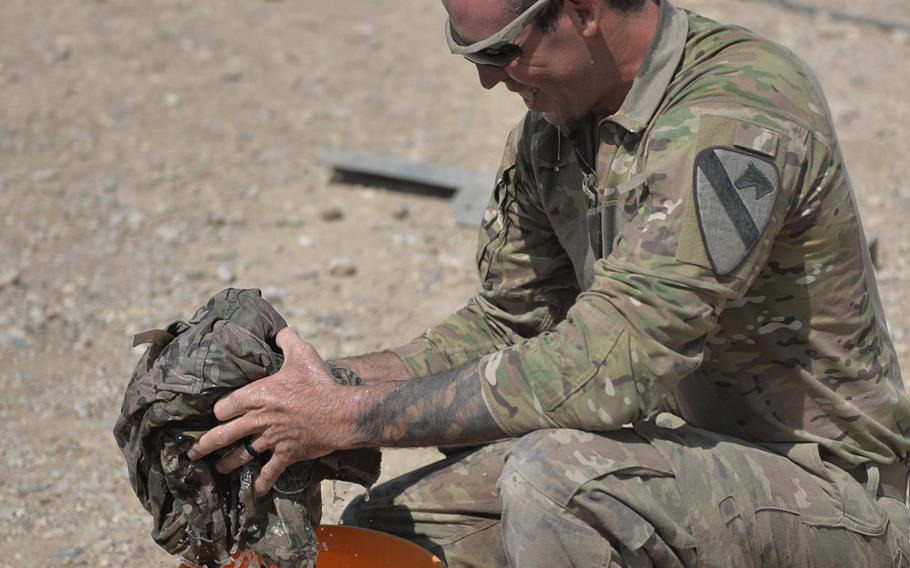 Spc. Gary Bartnik, a Paladin howitzer crew member, washes laundry on the artillery firing line at a joint tactical base near the northern Iraq town of Tal Afar on Sunday, Aug. 27, 2017.