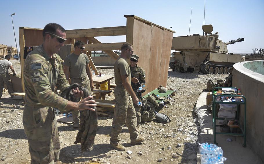 Paladin howitzer crew members prepare to roll out to a new location from their tactical base near the northern Iraq town of Tal Afar on Sunday, Aug. 27, 2017, as Spc. Gary Bartnik finishes up his laundry.