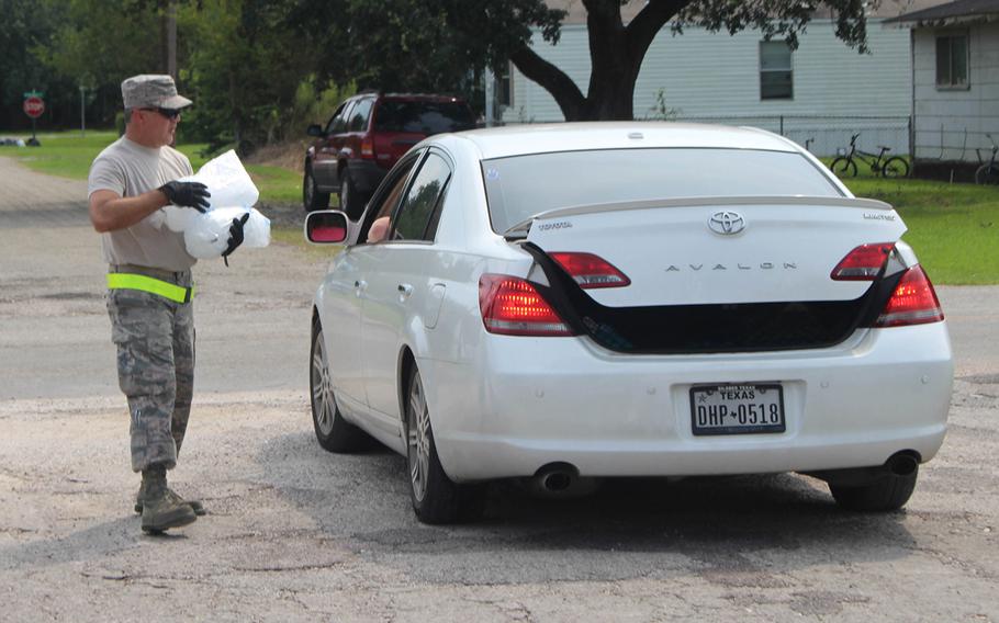 A member of the 136th Airlift Wing of the Texas National Guard provides ice to a resident of China, Texas, on Sept. 3, 2017.