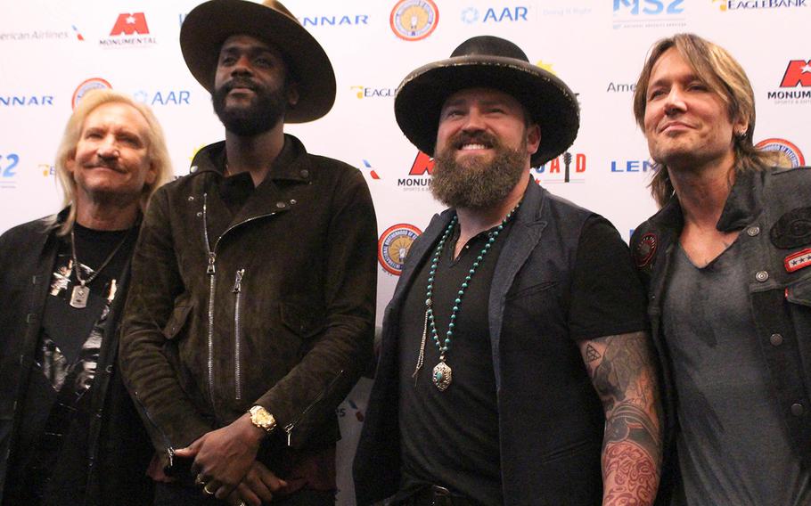 Joe Walsh, Gary Clark Jr., Zac Brown and Keith Urban pose for photos before the start of VetsAid, at Eagle Bank Arena, Wednesday, Sept. 20, in Fairfax, Va. VetsAid is a benefit concert aimed at helping 18 organizations who assist veterans and military families.