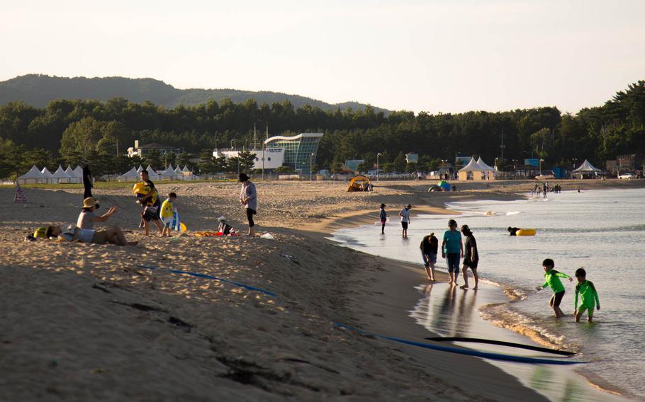 Tourists enjoy the beach in Goseong, South Korea, Saturday, Aug. 26, 2017.
