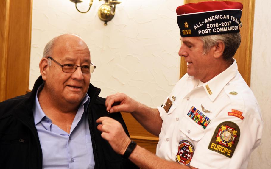 VFW Tower Post 10692 commander James Joyce, right, pins a Vietnam veteran lapel pin onto Baldemar Guevara in Grafenwoehr, Germany, Tuesday, Oct. 24, 2017.