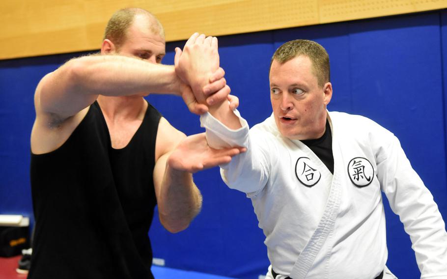 Pfc. Nikolas Petrosyan, left, practices an aikido move on base chaplain Maj. Kevin Hovan during an aikido class at Grafenwoehr, Germany, Tuesday, Oct. 24, 2017.
