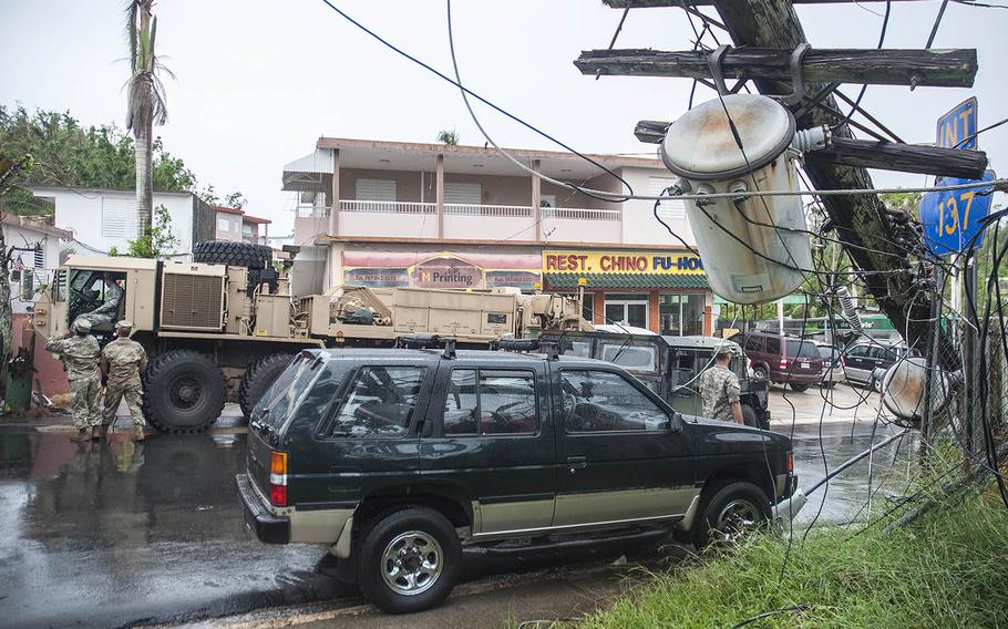 Many power lines, blown over by the fierce winds of Hurricane Maria in September, remain down like this one outside the Jamie A. Collaza High School in Morovis, Puerto Rico, where a convoy of military transport vehicles personnel arrived Tuesday, Nov. 7, 2017, during a food and water humanitarian distribution event.