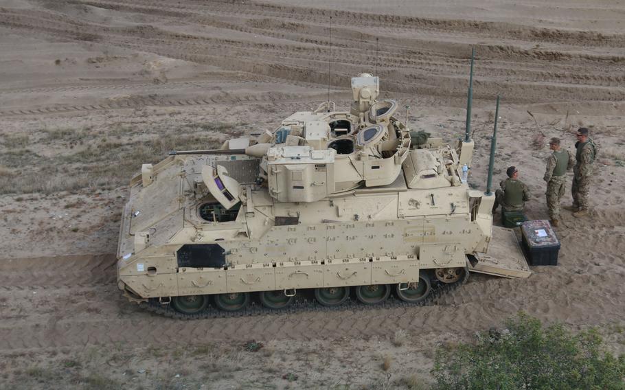 Troops stand by an M2A3 Bradley Fighting Vehicle awaiting their turn to conduct a firing systems check at the Presidenski Range, Trzebien, Poland, Sept. 20, 2017.