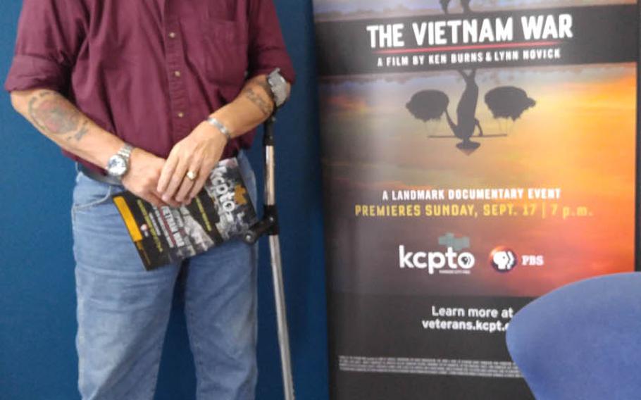 Vietnam veteran and poet John Musgrave stands in front of the poster for "The Vietnam War" documentary, in which he is featured, during a Kansas preview ahead of the film's airing on PBS in September. Musgrave overcame severe post-traumatic stress after being shot in the face and chest in November 1967, sustaining life-threatening and permanently disabling injuries, and now helps to counsel post-911 veterans. Photo courtesy of John Musgrave