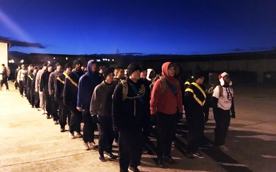 Soldiers primarily with the Army's 2nd Cavalry Regiment, along with some of their family members, stand in formation after running for the holiday Family Fun Run and Toy Drive, at Vilseck, Germany, Wednesday, Dec. 13, 2017.