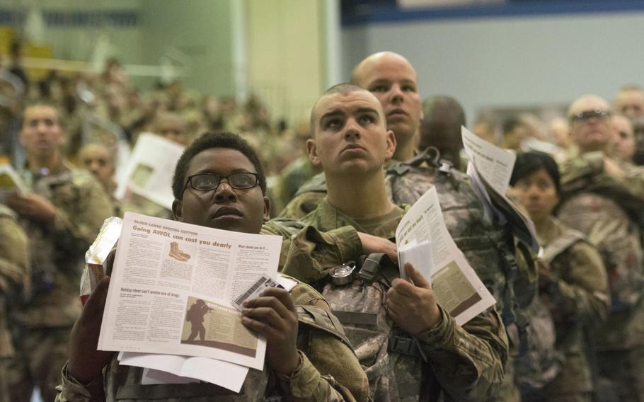 Trainees look watch the news on a big screen while they stand in line before processing at the Solomon Center at Fort Jackson, S.C., on Monday, Dec. 18, 2017, for departure on Victory Block Leave. Roughly 6,000 trainees from Fort Jackson will be traveling home for the holidays before coming back to their post to continue training.