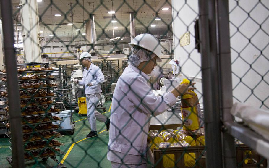 Bakers package bread and doughnuts at the Army and Air Force Exchange Service bakery at Camp Market, South Korea, Tuesday Dec. 5, 2017.