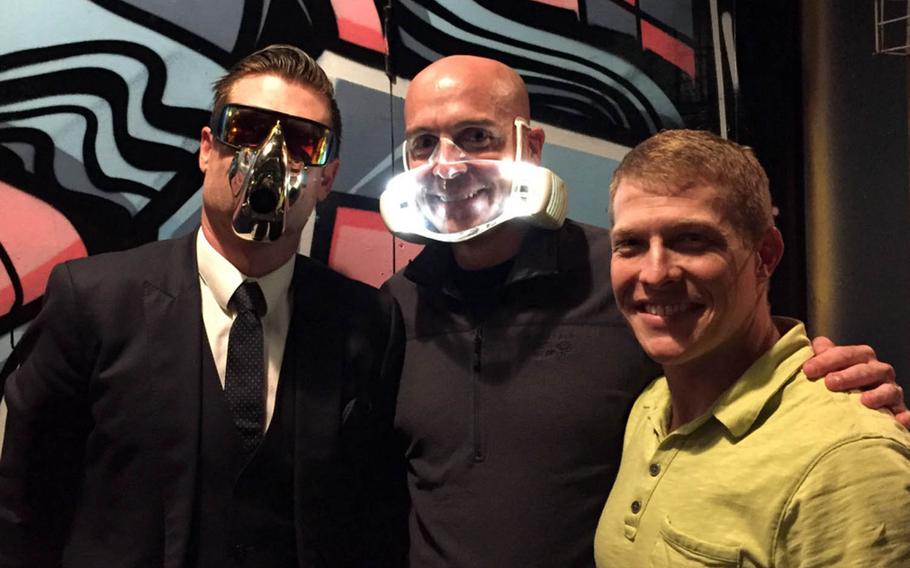 Dan Bowden, left, CEO of the high-tech startup O2O2, and Cmdr. Tom Ogden don prototype facemasks the company is developing in Auckland, New Zealand. Lt. Cmdr. Derek Fletcher, right, recently spent five weeks at the company evaluating the product's potential uses on Navy flight decks.