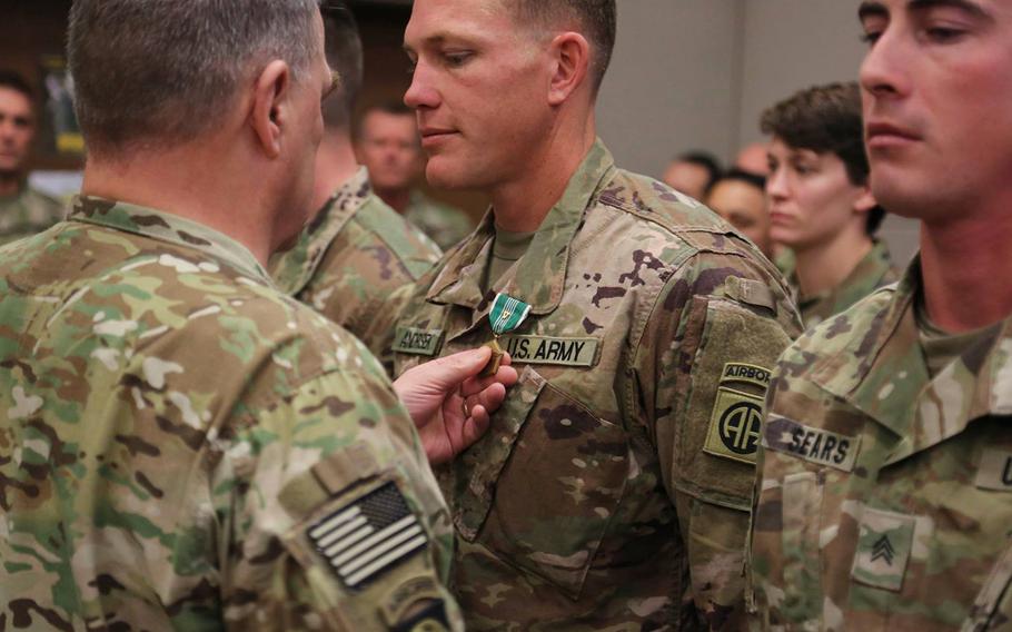 Gen. Mark Milley, chief of staff of the Army, pins an Army Commendation Medal with V device on Sgt. Mark Andrisek at Bagram Air Field, Afghanistan, on Tuesday, Dec. 19, 2017. Andrisek, along with Sgt. Joshua Sears, right, took quick action that saved American lives following a suicide car bombing on their route-clearing platoon convoy on Nov. 13, 2017.
                