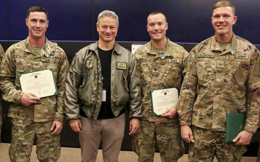 Actor Gary Sinise, center, poses at Bagram Air Field on Tuesday, Dec. 19, 2017, with three soldiers after they received Army Commendation Medals with V devices for their bravery in reaction to a Monday, Nov. 13, 2017 suicide car bombing attack on their convoy in Kandahar province, Afghanistan. The soldiers, from left to right, are Sgt. Joshua Sears, Spc. Garrett Young and Sgt. Mark Andrisek.
                