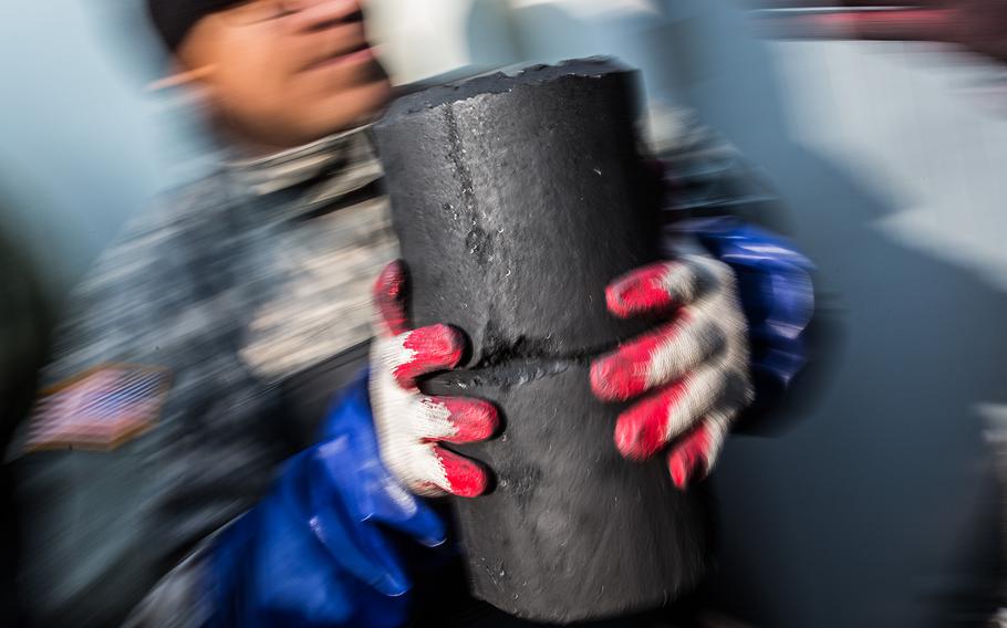A soldier from 1st Battalion, 38th Field Artillery Regiment carries charcoal briquettes in Yeoncheon, South Korea, Thursday, Dec. 28, 2017.