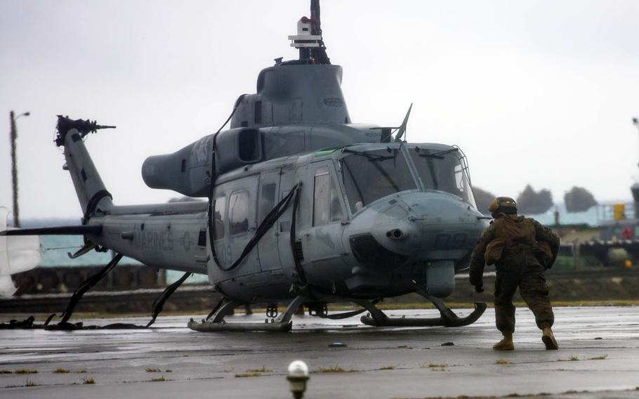Marines with Heavy Marine Helicopter Squadron 466 prepare to lift a UH-1Y Venom after it made a precautionary landing in Okinawa, Japan, Monday, Jan. 8, 2018.
