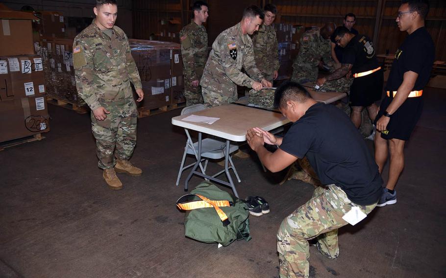 A soldier with the 25th Infantry Division in Hawaii tests the flexibility of the trousers of the Improved Hot Weather Combat Uniform earlier this month during fielding of about 800 prototypes of the lighter, faster-drying uniform.