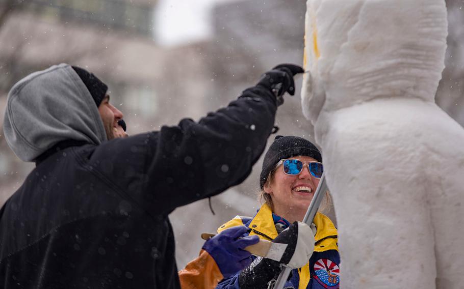 Petty Officer 3rd Class Christopher Hamilos and Petty Officer 2nd Class Leah Alstad detail Naval Air Facility Misawa's sculpture for the 69th annual Sapporo Snow Festival in Hokkaido, Japan, Jan. 31, 2018.