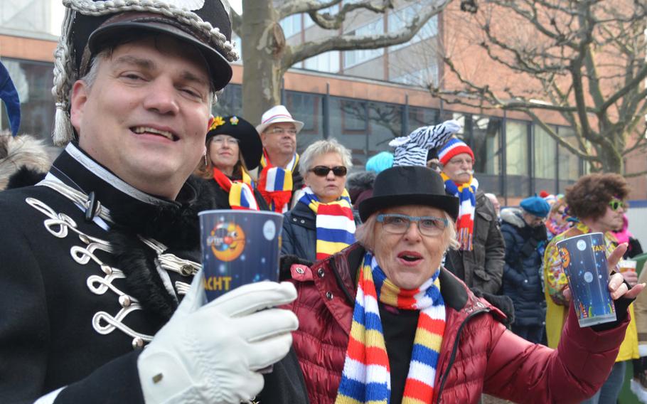Prost! Revelers celebrate Weiberfastnacht, or women's carnival, in Mainz, Germany, Thursday, Feb. 8, 2018. The scarves are in the white, red, blue and yellow colors of the Mainz carnival.