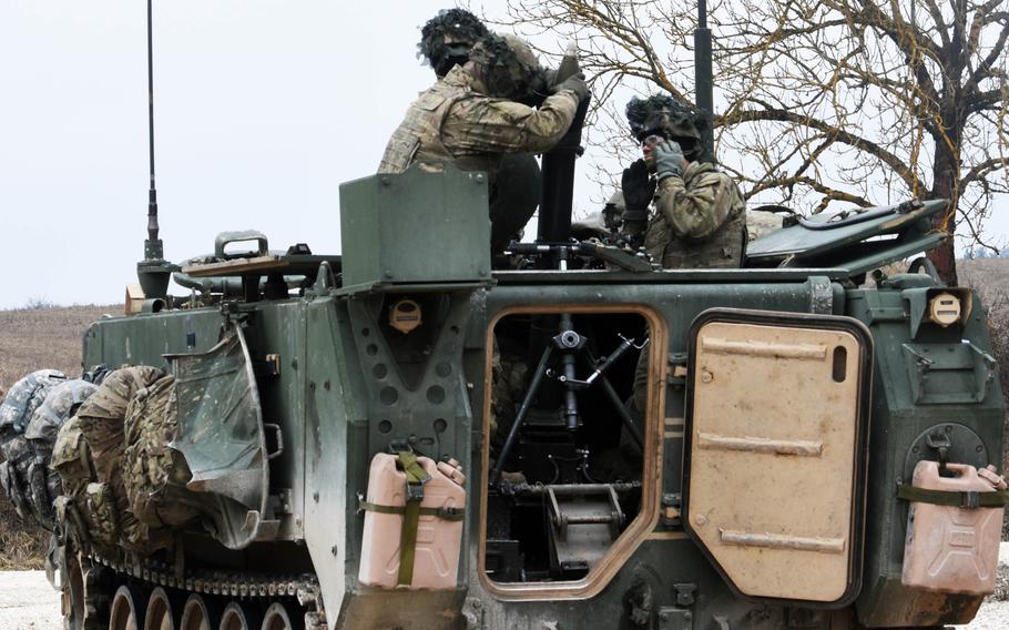 Soldiers with the 2nd Armored Brigade Combat Team load a 120 mm mortar inside of an M113 mortar carrier, during live-fire training at Grafenwoehr, Germany, Thursday, Feb. 8, 2018.