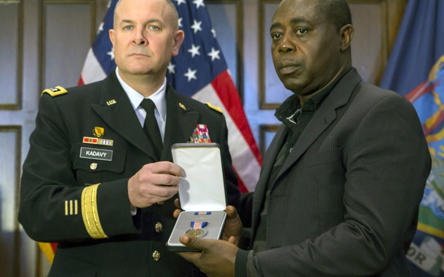 Lt. Gen. Timothy J. Kadavy, director of the Army National Guard, presents Kwabena O. Mensah, father of Pfc. Emmanuel Mensah, with the Soldier's Medal, the Army's top award for valor outside of combat during a ceremony Feb. 16, 2018, at Fordham University in the Bronx, N.Y.