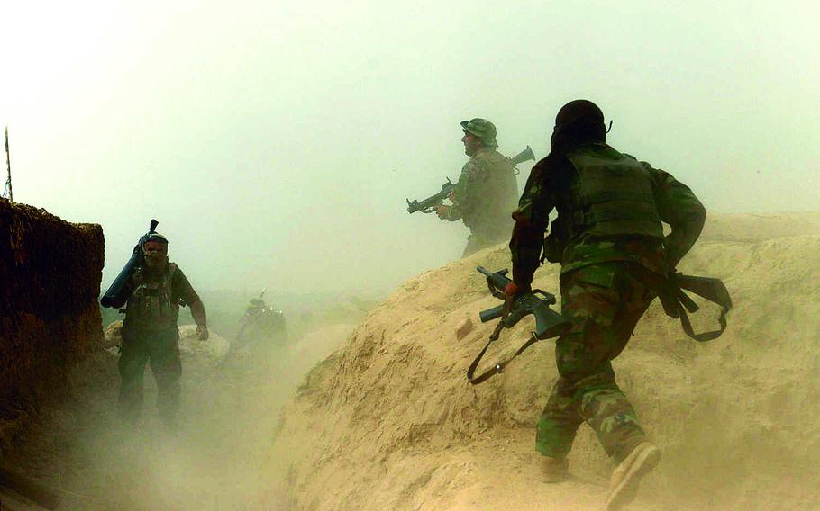 Afghan army soldiers run for position during a firefight with Taliban gunmen in Kunduz city in 2015. Afghan President Ashraf Ghani on Wednesday reiterated a call for the Taliban to join peace talks following a spate of deadly insurgent attacks.