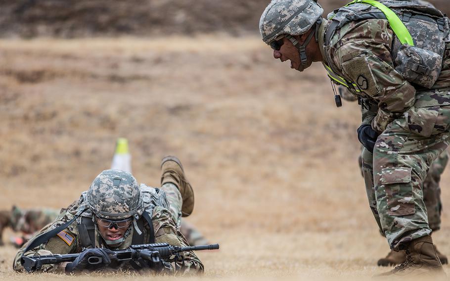 Pfc. Demarious Quick of Headquarters and Headquarters Company, 19th Expeditionary Sustainment Command receives extra encouragement during a stress shoot at Masan, South Korea, Wednesday, March 7, 2018.