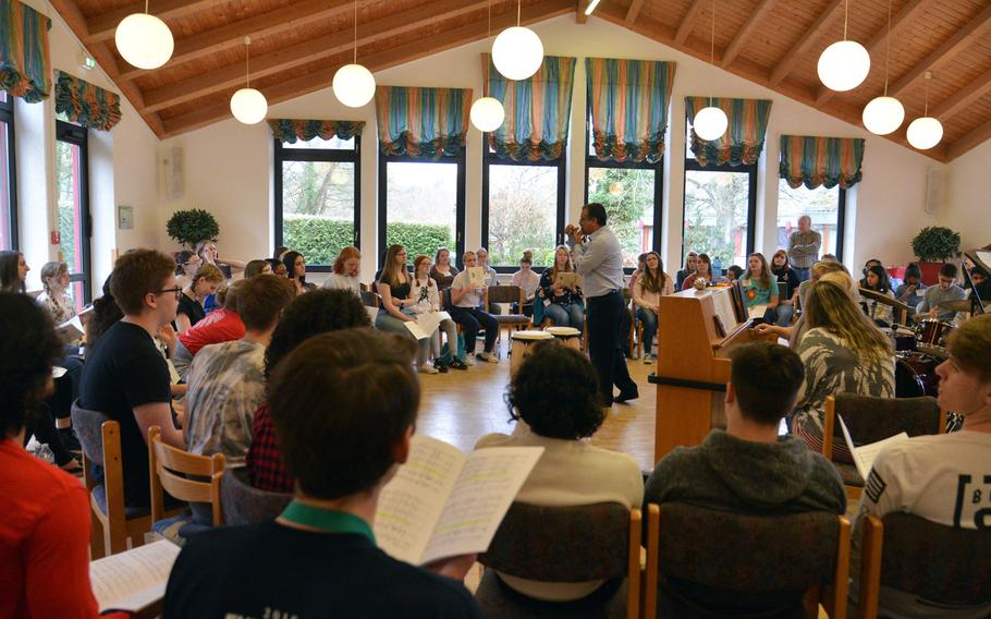 Jose Rivera, the guest conductor for the choir at this year's DODEA-Europe Honors Music Festival, leads the singers through rehearsal, Tuesday, March 13, 2018.