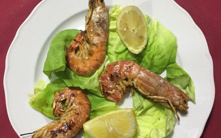 A trio of jumbo shrimp is one of many seafood choices at Ristorante Pizzeria Il Pentolone in the Parco Azzurro apartment complex in Pozzuoli, Italy.