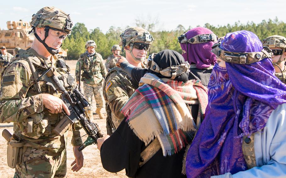 Soldiers with the Army's 1st Security Force Assistance Brigade provide security, keeping role players portraying concerned Afghan villagers back as their comrades tend to individuals wounded in a firefight during a training scenario Jan. 15 at the Joint Readiness Training Center at Fort Polk, La.