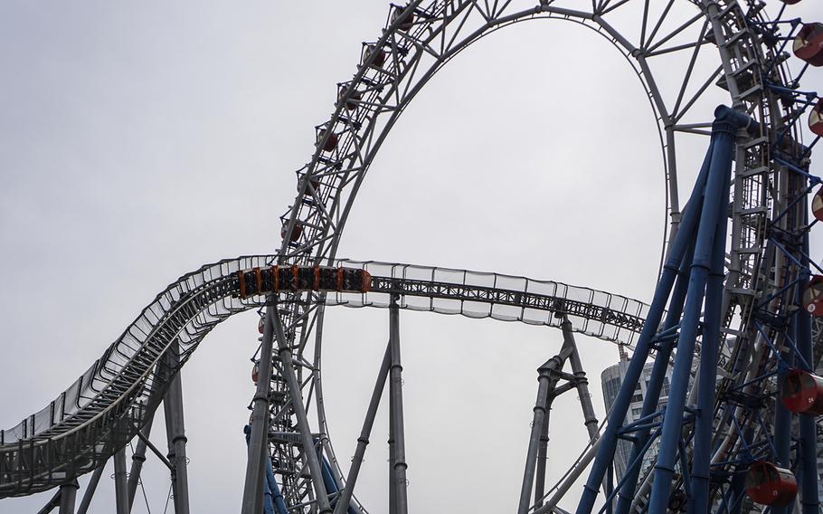 Thunder Dolphin passes through the Big O, the world's first centerless Ferris wheel, at the Tokyo Dome City theme park.