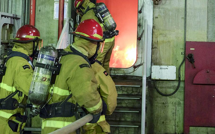 Sailors prepare a hose to extinguish a fire during recent damage-control training at Yokosuka Naval Base, Japan.