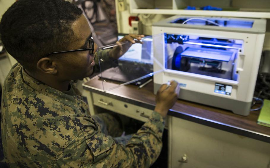 Sgt. Adrian Willis, a computer and telephone technician with Combat Logistic Battalion 31, 31st Marine Expeditionary Unit, explains the functions of a 3-D printer aboard the USS Wasp while underway recently in the Pacific Ocean.