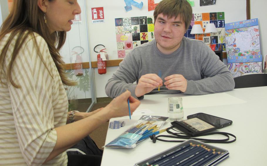 Vicenza Art and Crafts Center supervisor Michelle Sterkowicz assists student Jack Dupree during a free-form art session for young people designed to build resiliency, held weekly at the base library.