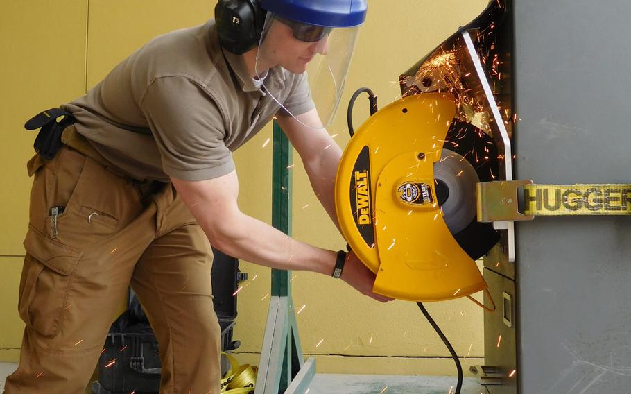 A Navy Seabee with the Naval Support Unit - State Department cuts a container at the U.S. Embassy in Kabul on Monday, April 10, 2017.