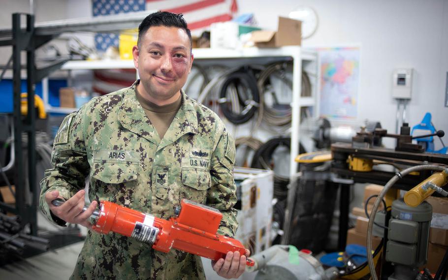 A Naval Beach Unit 7 sailor shows off an actuator used to manipulate hovercraft rudders near Sasebo Naval Base, Japan, May 10, 2018.