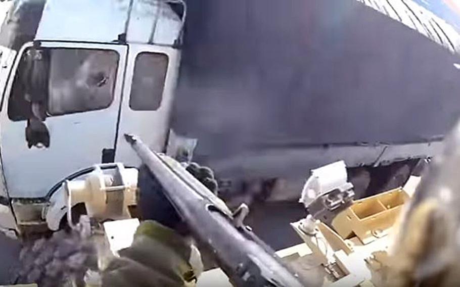 A screengrab of the video that shows a U.S. servicemember firing a shotgun at a truck in Afghanistan. An investigation found that the driver ignored warnings and the servicemember fired a beanbag, in accordance with military rules.