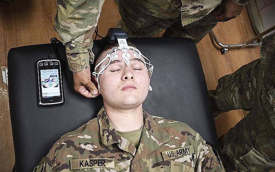 Army Pvt. Jason Kasper, a medic with the 2nd Squadron (Armored), 1st Cavalry, 4th Infantry Division, closes his eyes as another medic places electrodes on his forehead to test for traumatic brain injuries. Soldiers at Advising Post Lightning trained Saturday on the smartphone-sized BrainScope device, a high-tech brain scanner that tests for traumatic brain injuries.