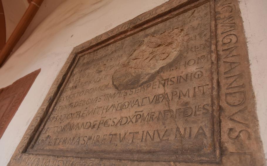 A tomb sealed in the wall at St. Stephan's church in Mainz, Germany, bears markings from an artillery shell. The church was nearly destroyed during World War II and was later rebuilt.