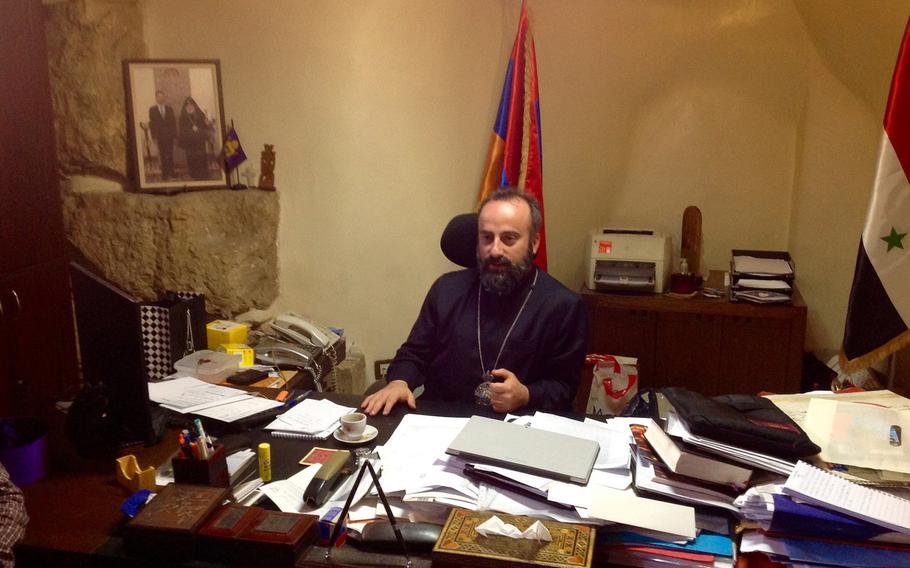 Armenian Orthodox Bishop Armash Nalbandian speaks to reporters in his office in Damascus, Syria, on Thursday, June 7, 2018. His church's school reopened recently after shelling of the mainly Christian area ended in April and rebel fighters were evacuated from a nearby suburb.