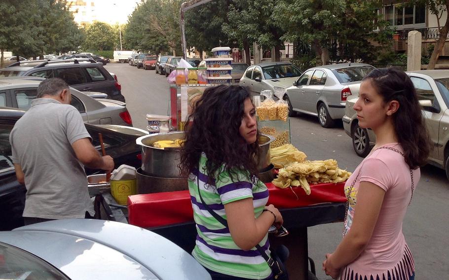 A vendor of boiled corn in downtown Damascus, Syria. The streets are now much more lively than they were a few months ago, when residents had to fear sporadic mortar and rocket fire from rebels who controlled the city' outskirts. Some 16,000 Damascenes are said to have perished during the seven-year war.