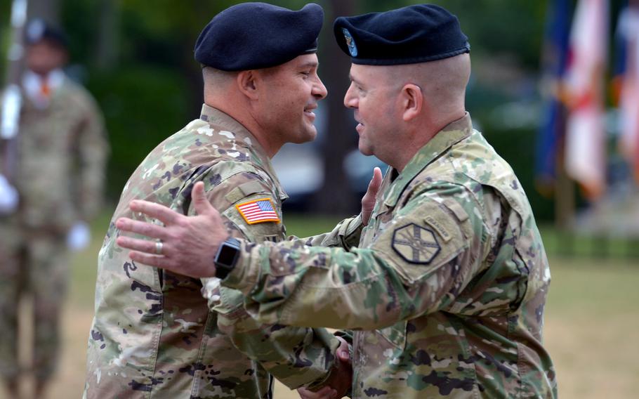 The outgoing commander of U.S. Army Garrison Rheinland-Pfalz, Col. Keith Igyarto, right, shakes hands with his successor, Col. Jason Edwards, at the unit's change-of- command ceremony in Kaiserslautern, Germany, Wednesday, July 11, 2018.