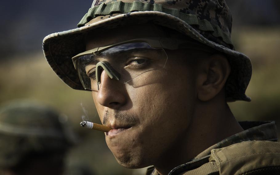 A Marine takes the last drag of his cigarette before conducting a live fire drill at Pohakuloa Training Area, Hawaii, Friday, July 13, 2018.