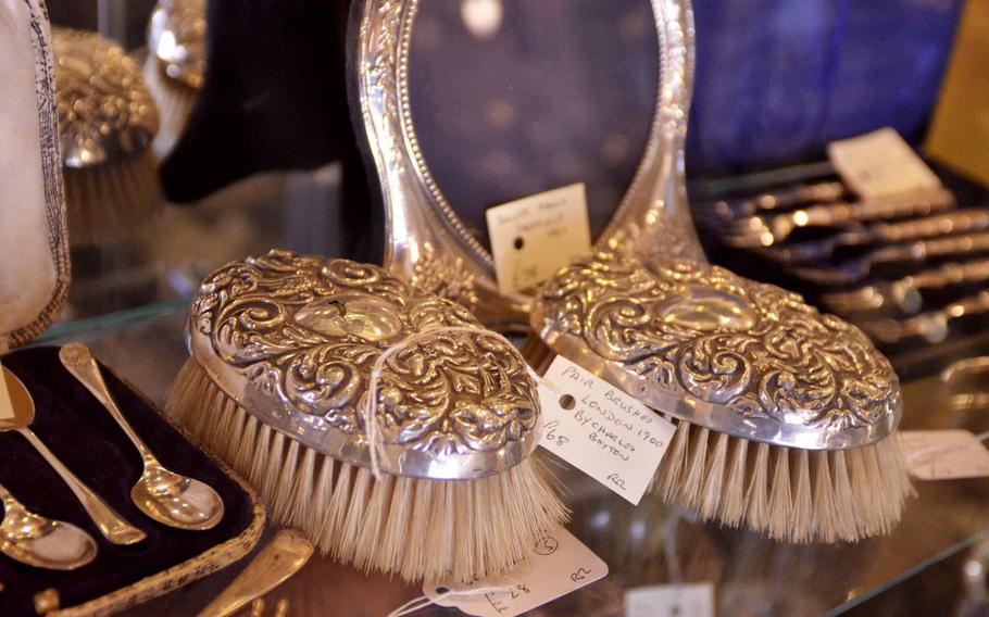 Silver brushes and dinnerware for sale at the Risby Barn Antique Centre in the village of Risby, England. 