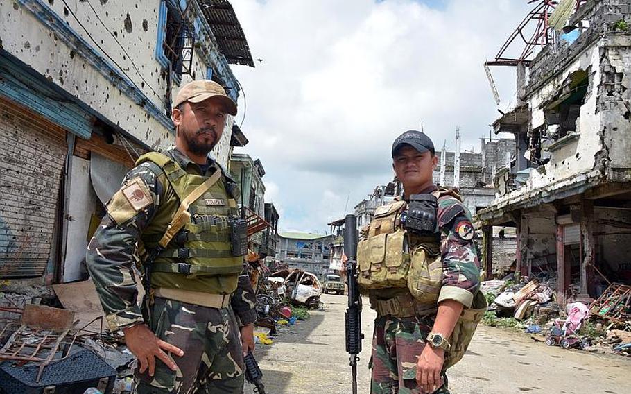 Philippine Rangers Capt. Alex Estabaya and Capt. Ramse Dugan, who fought in the battle to liberate Marawi from Islamic State insurgents, stand in Marawi City, Philippines, in November.