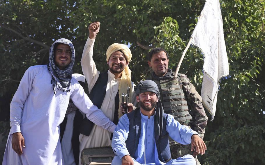 Residents of a Taliban district and an Afghan army soldier pose for photos with a Taliban flag in Logar province, June 16, 2018. Across the country, photos of Taliban and government troops taking photos of each other spread online during an unprecedented cease-fire between the Taliban and the Afghan government.